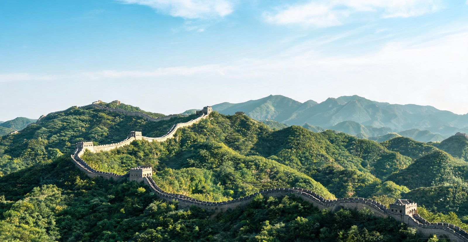 The Great Wall of China winding across green mountain ridges